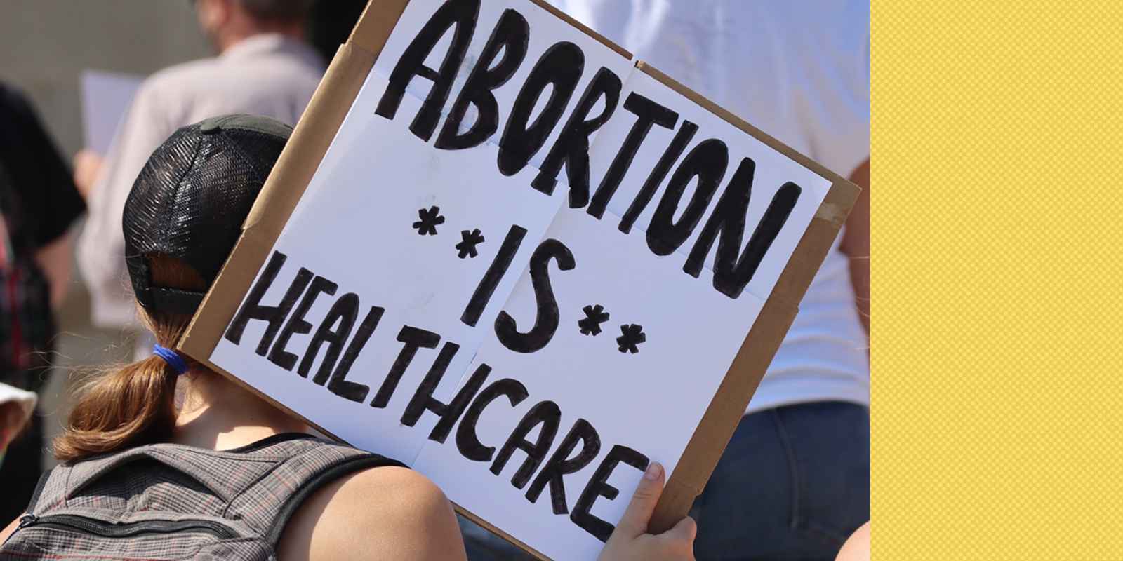 A Nebraskan holds a sign at a rally reading "Abortion is healthcare".