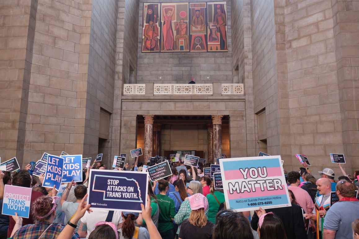 Supporters of trans youth gather at the Nebraska state capitol with signs in support to trans youth