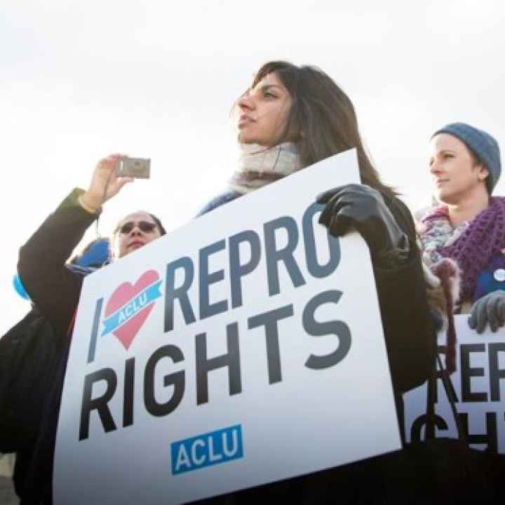 A woman holds a sign reading "I love repro rights."