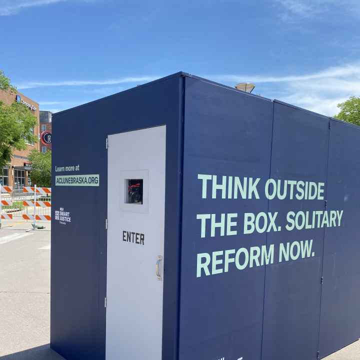 The ACLU of Nebraska's solitary replica cell reads "Think outside the box. Solitary reform now."