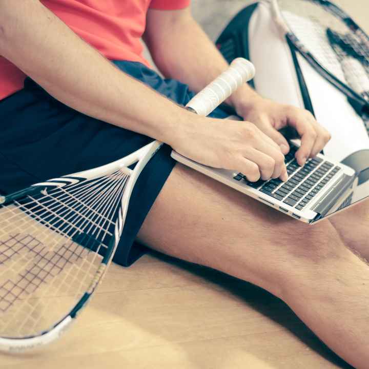 student with laptop and tennis racket